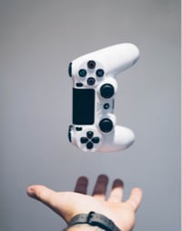 image of a hand tossing a ps4 controller in the air